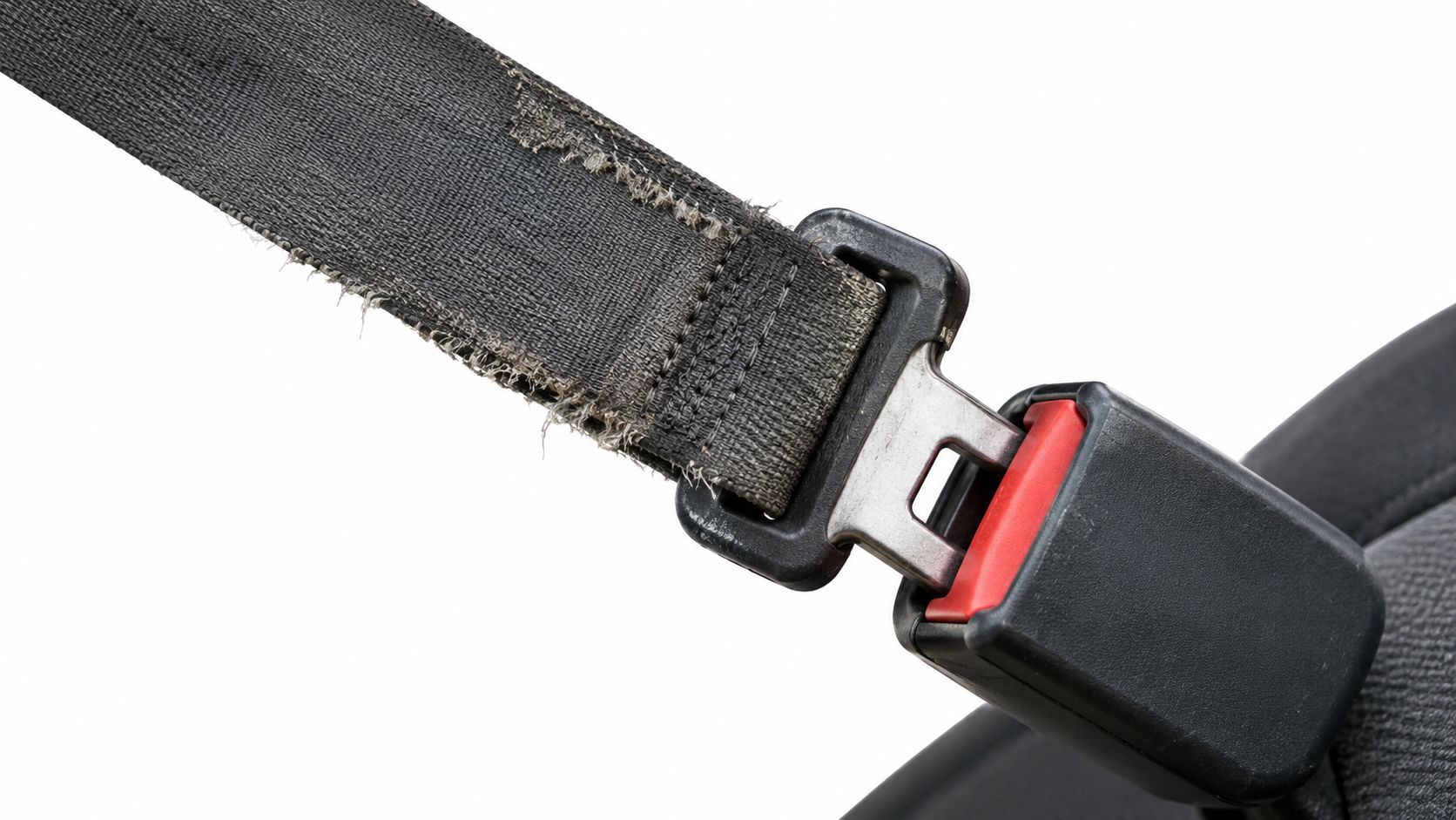 A close-up view of a worn, frayed black nylon seat belt buckled into its metal release mechanism.