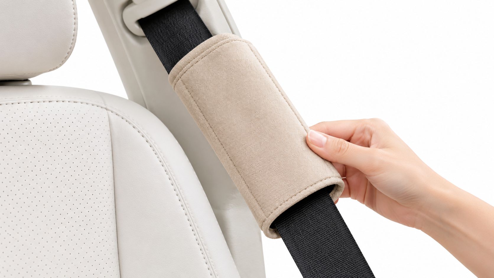 A hand adjusts a beige fabric seatbelt strap cover wrapped around a black car seatbelt.